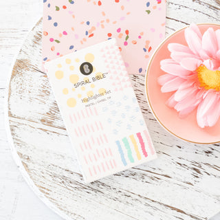 Spiral Bible highlighter set packaging with pastel chisel tip markers on a white wooden surface
