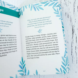 Open book with a blue floral bookmark on a wooden surface
