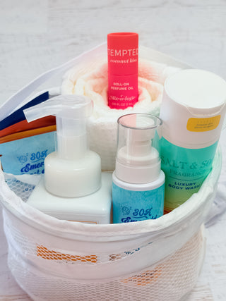 Dorm Room Essentials Mixologie Bundle containing body wash perfume oil and soap in a white mesh bag