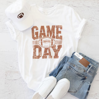 Vintage Game Day Football Brown and White Graphic Tee with a white cap, blue jeans, and white shoes