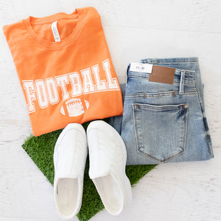 Game Day Tee Team Colors Orange and White Graphic Tee with jeans and white sneakers on artificial grass