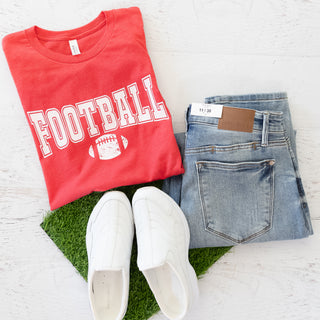 Game Day Tee Team Colors Red and White Graphic Tee with jeans and white slip-on shoes on artificial grass
