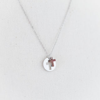 Necklace with a cross pendant on a light gray background