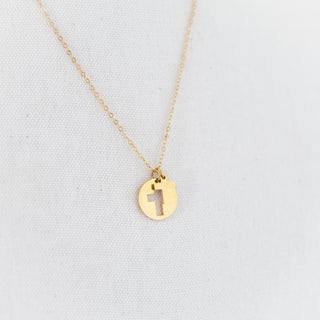 Gold necklace with a pendant on a light gray background
