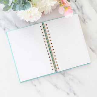 Open Hot Mess But I am Blessed spiral wire bound mint green journal on marble surface with flowers