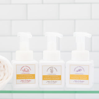 Three Mixologie luxe foaming hand soap bottles in cherry coconut cashmere honey and vanilla patchouli scents