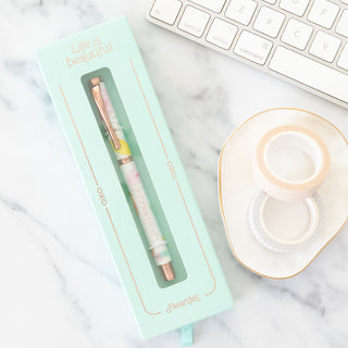 Life is Beautiful Heartfelt ball point pen in mint green packaging next to washi tape on a marble desk