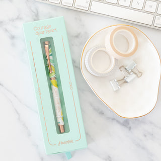 Courage Dear Heart ball point pen in mint green packaging with washi tape and binder clips on marble surface