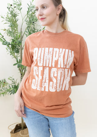 Woman wearing a yam colored Pumpkin Season distress print graphic tee