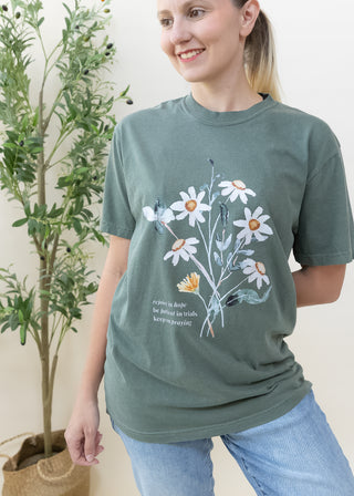 Woman wearing dark green Rejoice in Hope Be Patient in Trials Keep on Praying graphic tee with floral design