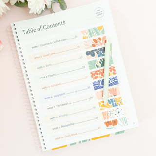 Table of contents page for The Bible in A Year A 52-Week Journey Through God's Word with a pen resting on top