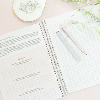 Open pages of The Bible in A Year A 52-Week Journey Through Gods Word with a pen and highlighter