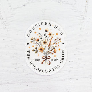 Consider How the Wildflowers Grow Luke 12:27 sticker with a floral bouquet and ribbon on a white background
