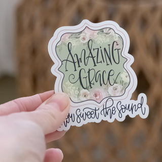 Hand holding Amazing Grace, How Sweet the Sound 3" Magnet Floral Design with delicate pastel flowers and script font in Christian Faith-based Boutique style