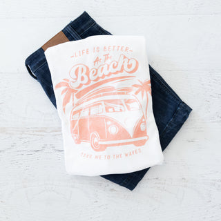 Towel with beach-themed design and text on a wooden surface