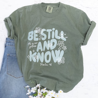 Be Still and Know Psalm 46 Deep Olive Graphic tee with light blue text and white flowers and butterflies