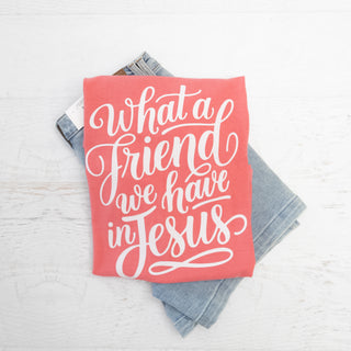 What a Friend We Have in Jesus Watermelon Color Graphic t-shirt folded on light wash jeans
