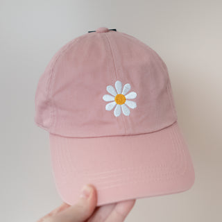 Single White Danity Daisy on Mauve Color Baseball Cap held against a plain background in soft lighting