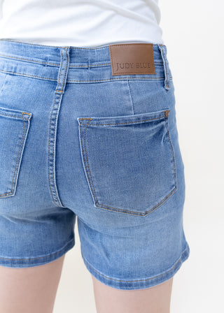 Back view of Judy Blue light denim shorts with high double waist fit and brown brand patch