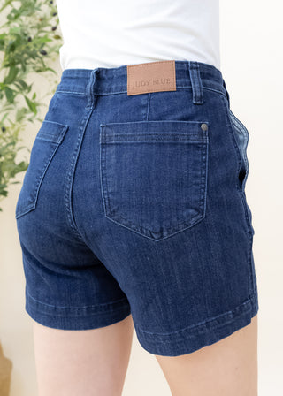 Back view of Judy Blue dark denim high waist shorts with brown leather brand patch