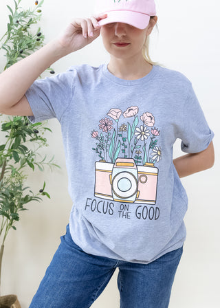 Heather grey t-shirt with a camera and wild flowers graphic and the text Focus on the Good