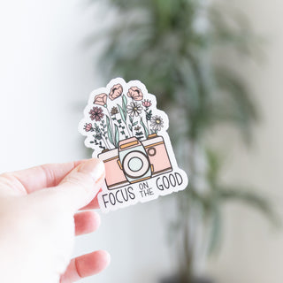 Focus on the Good Old Fashion Camera with Flowers sticker held in hand