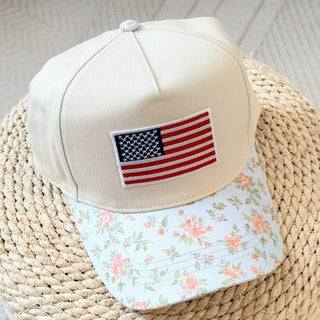 Cap with American flag patch and floral visor on a woven surface