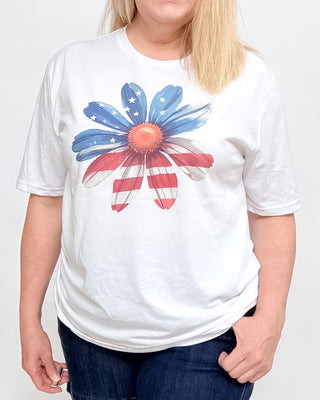 White t-shirt with a colorful flower design on a plain background