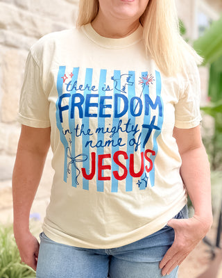 Person wearing a t-shirt with 'there is freedom in the mighty name of Jesus' text.