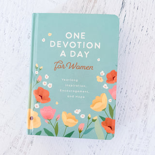 Book titled 'One Devotion A Day For Women' with floral design on a light wooden surface
