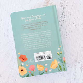 Book with floral design and text on a light wooden surface