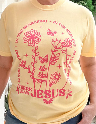 Yellow t-shirt with pink floral and butterfly design and text on a person wearing it.