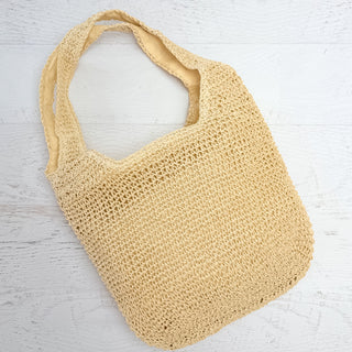 Beige crochet bag on a light wooden surface
