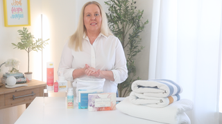 Woman presenting Mixologie laundry products and towels on a table
