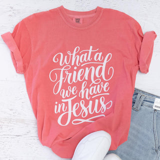 Coral short sleeve t-shirt with white cursive text reading What a friend we have in Jesus